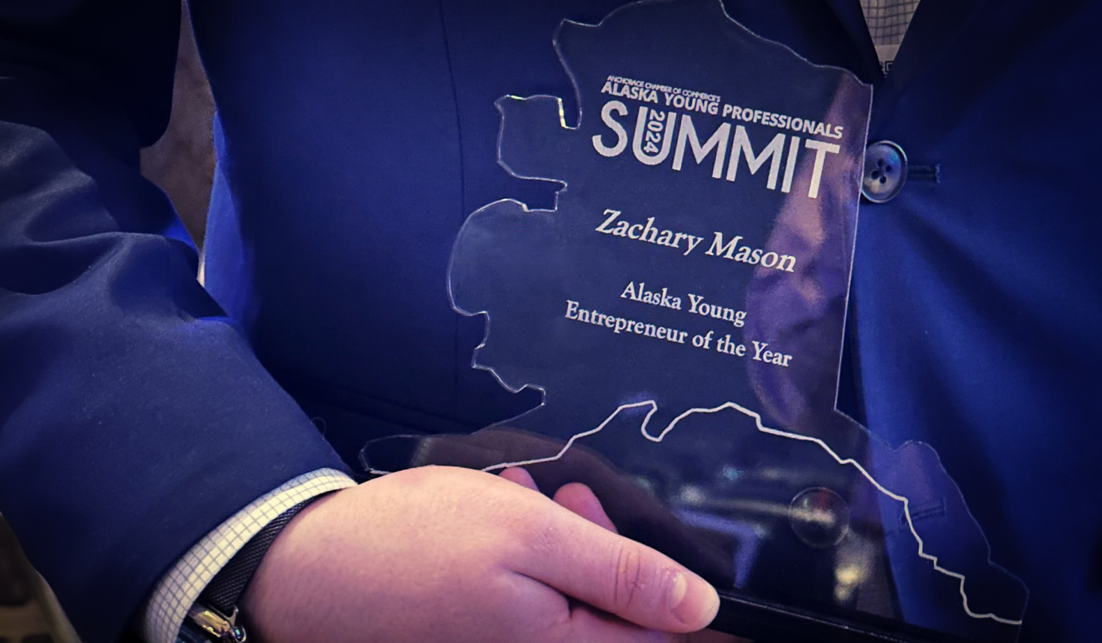 Photo of Zachary Mason holding award for 2024 Young Entrepreneur of the Year